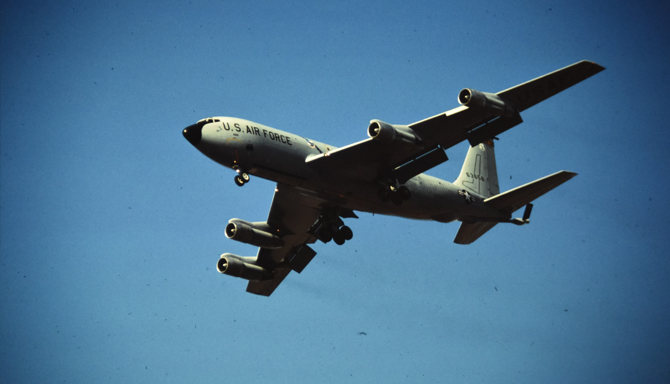 KC-135 stratotanker aircraft midflight in a clear blue sky