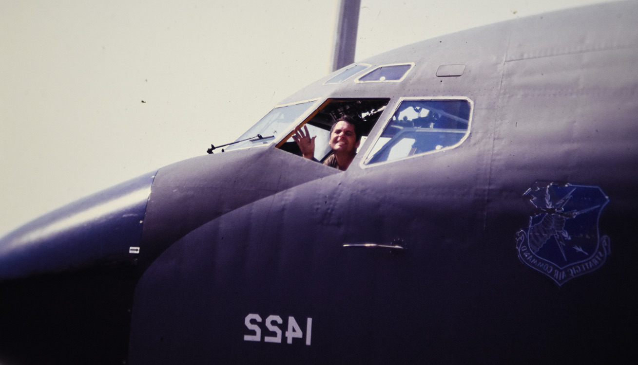 close up of a pilot smiles and waves from the inside of a cockpit on a kc-135